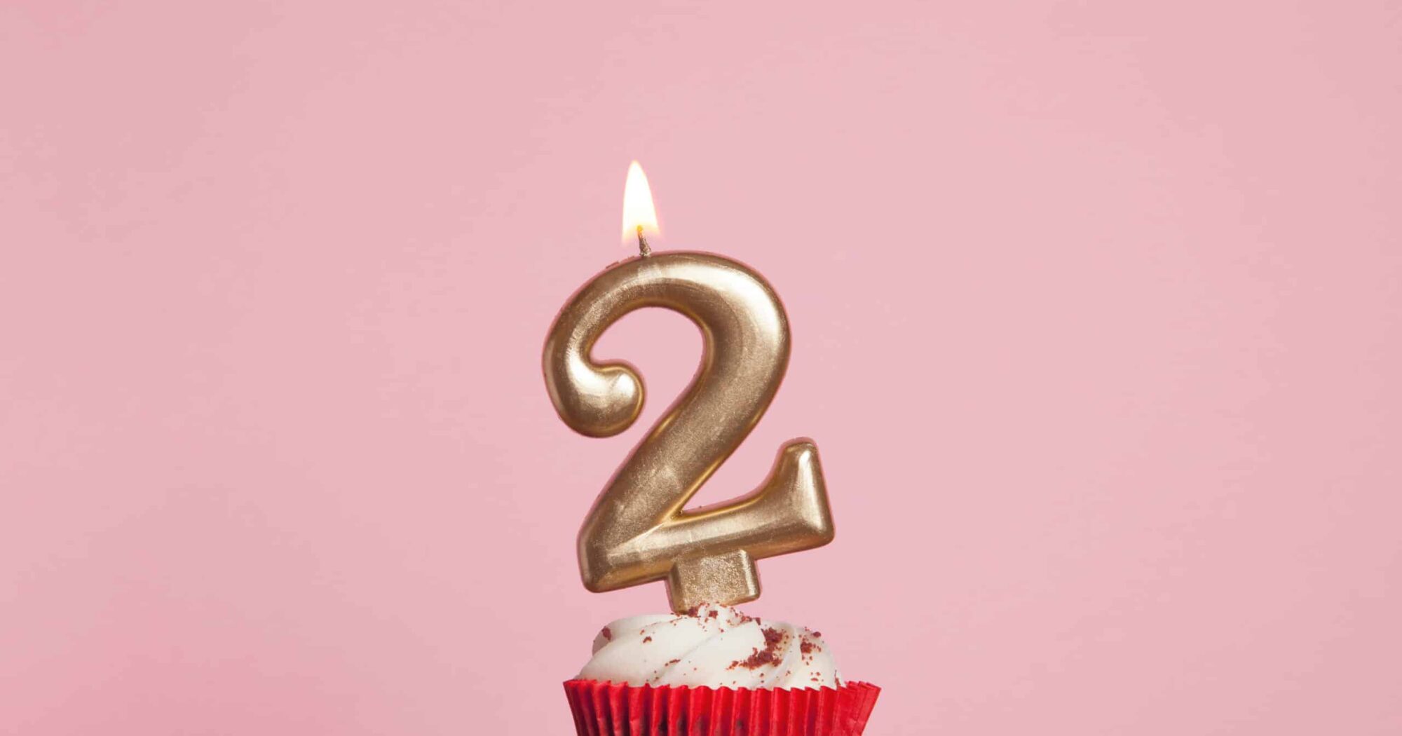 Number,2,Gold,Candle,In,A,Cupcake,Against,A,Pastel